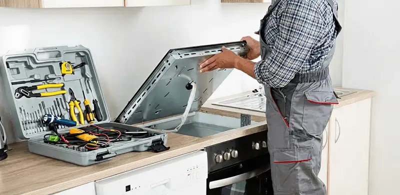 Handyman repairing a cooktop and checking wiring connections in Fort Collins, CO
