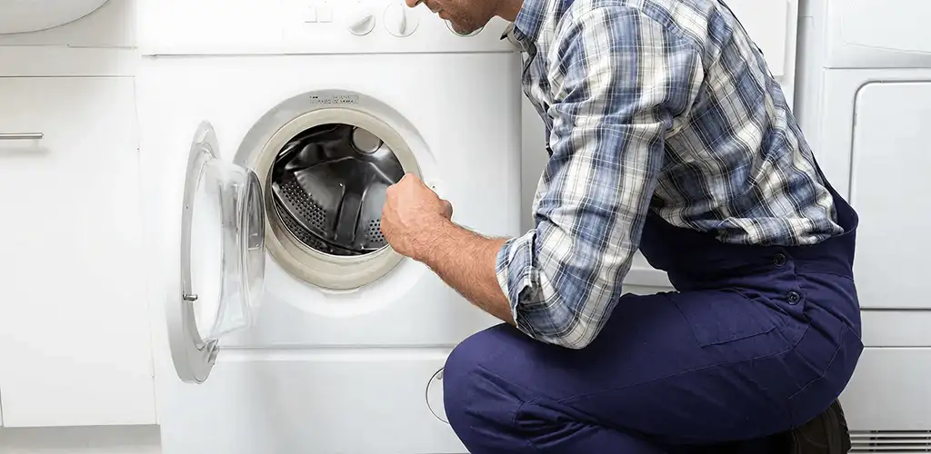Handyman inspecting a dryer drum and internal parts for repair in Fort Collins, CO