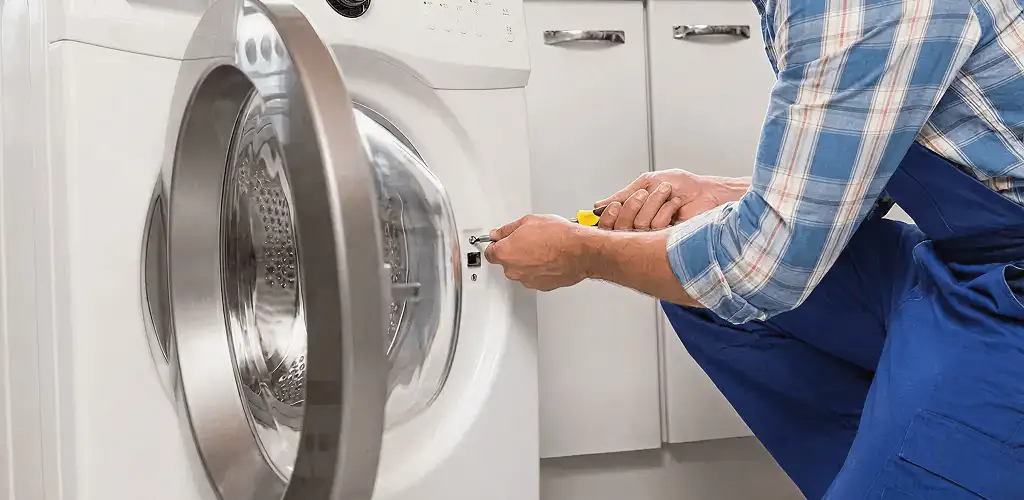 Handyman repairing a clothes dryer and checking electrical connections in Fort Collins, CO