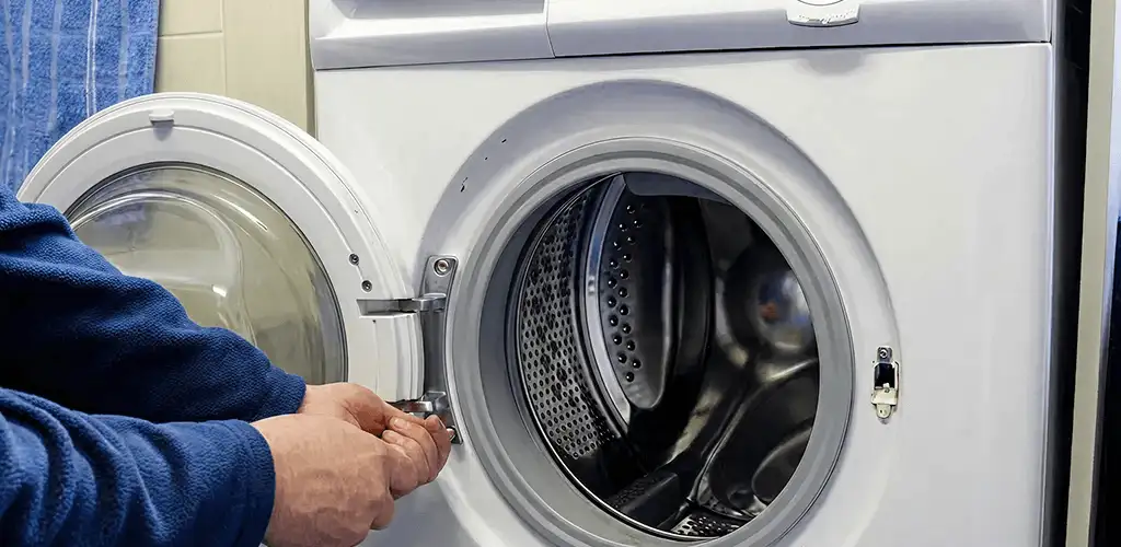 Washing machine repair handyman checking a front-load washer door and latch in Fort Collins, CO