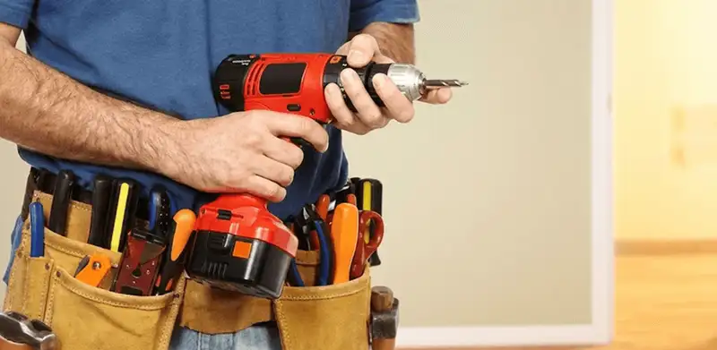 Handyman holding a power drill for home repairs and installations in Fort Collins, CO