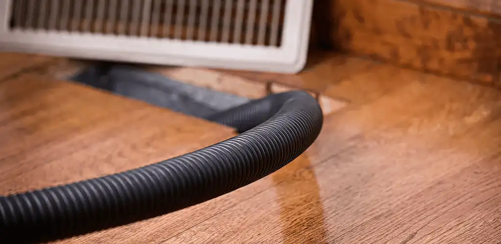 Air duct cleaning hose inserted into a floor vent for ductwork cleaning in Fort Collins, CO